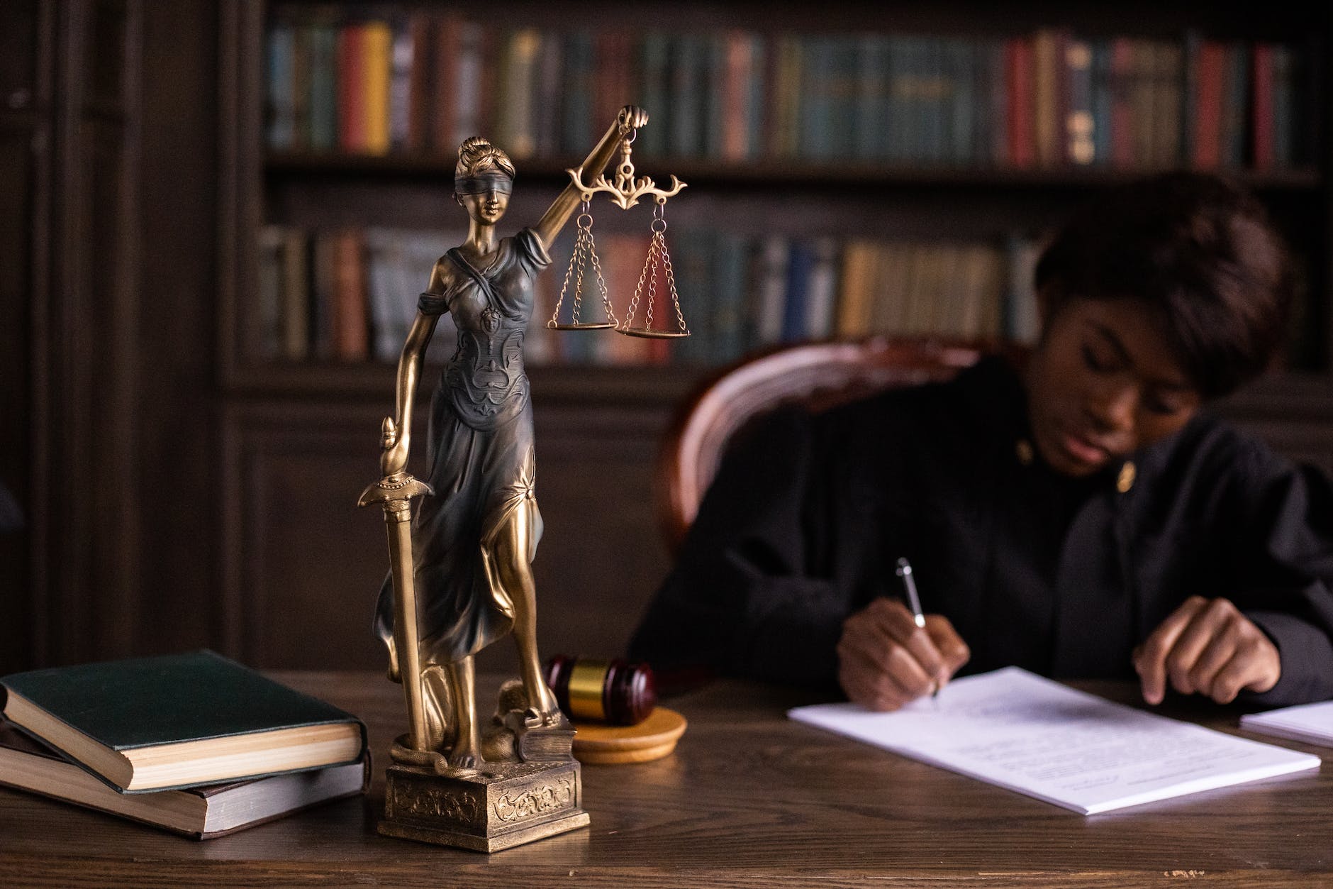 a figurine of the lady justice on the table of a judge
